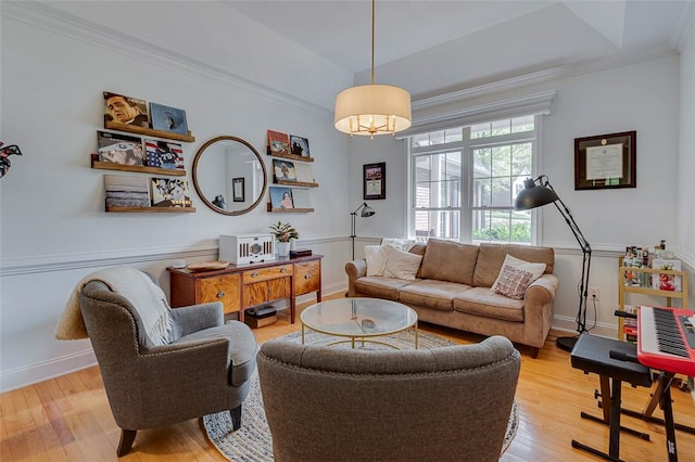 living room with baseboards, light wood-style floors, and crown molding
