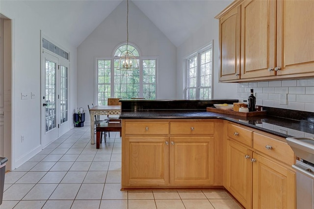 kitchen with lofted ceiling, a notable chandelier, light tile patterned floors, and a healthy amount of sunlight