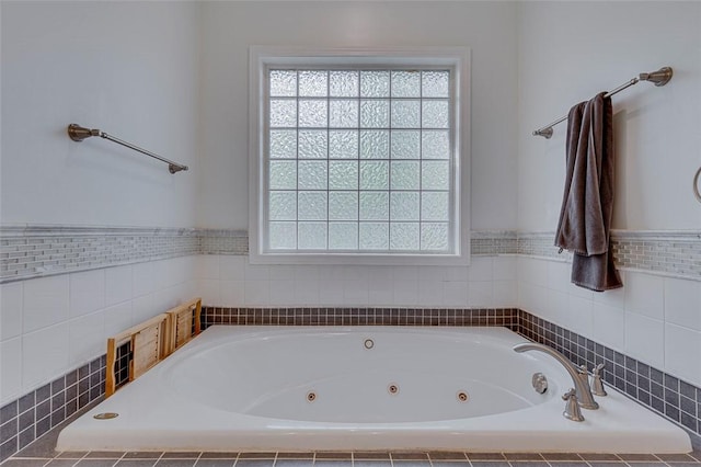 bathroom featuring a jetted tub and a wainscoted wall