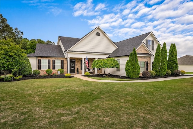 view of front of property featuring a front lawn, a porch, and brick siding