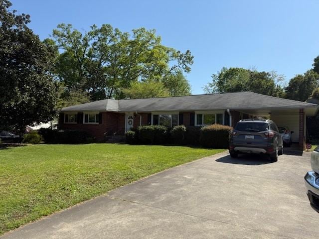 single story home with concrete driveway, a front yard, and an attached carport