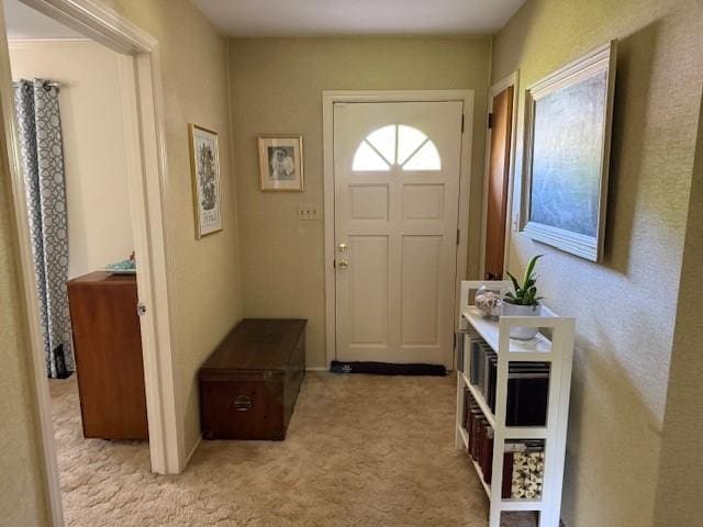 doorway to outside featuring light carpet