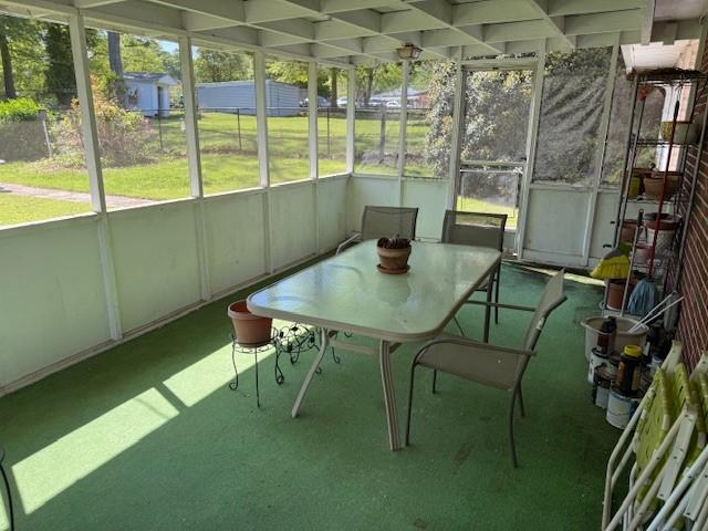 sunroom with a wealth of natural light and outdoor dining area
