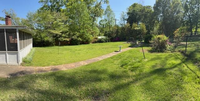 view of home's community with a yard and fence