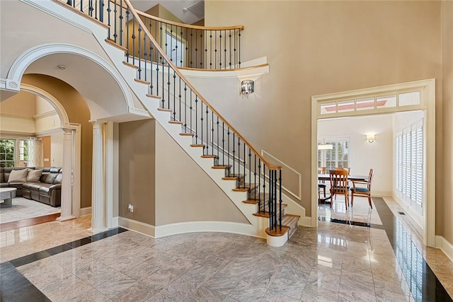 107 Amanda Dr, Anderson, SC 29621 - staircase with marble finish floor, decorative columns, arched walkways, a high ceiling, and baseboards