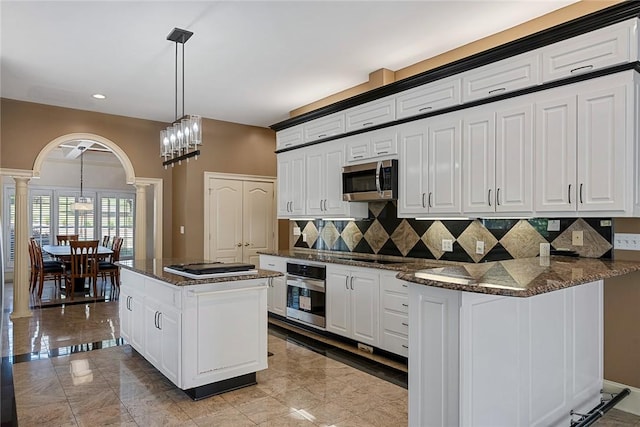 107 Amanda Dr, Anderson, SC 29621 - kitchen with stainless steel appliances, ornate columns, white cabinetry, arched walkways, and decorative backsplash