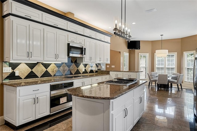 107 Amanda Dr, Anderson, SC 29621 - kitchen featuring stainless steel appliances, tasteful backsplash, a kitchen island, and white cabinets