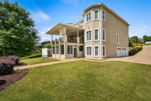 107 Amanda Dr, Anderson, SC 29621 - rear view of house featuring an attached garage, a balcony, a yard, concrete driveway, and stucco siding
