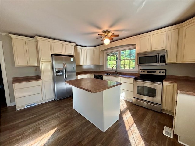 5192 Davis Cir, Anderson, SC 29625 - kitchen with stainless steel appliances, a sink, dark wood-style flooring, cream cabinetry, and dark countertops