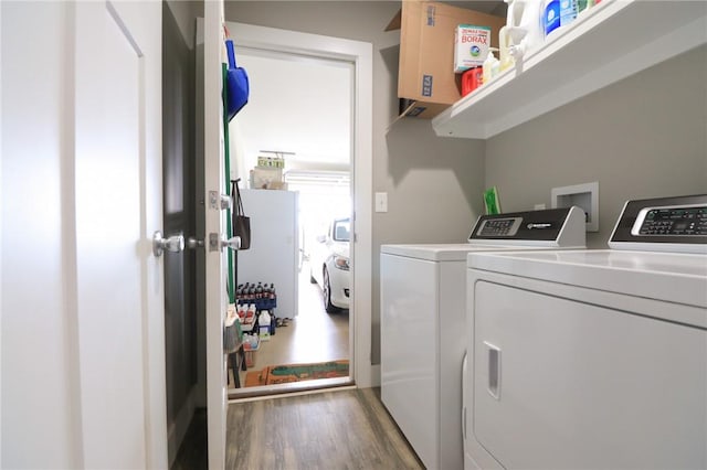 laundry area with separate washer and dryer, laundry area, and wood finished floors