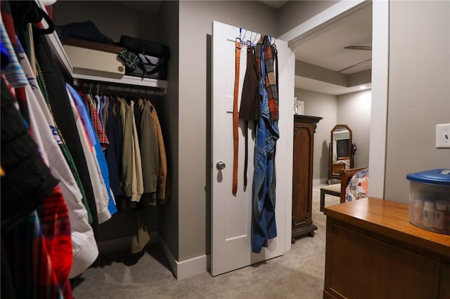walk in closet featuring light carpet