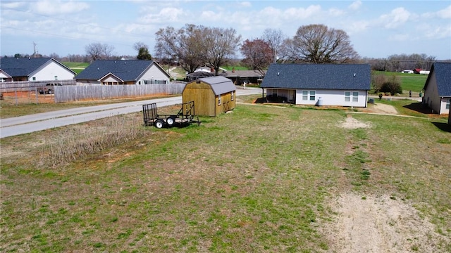 view of yard with an outdoor structure, fence, and a shed