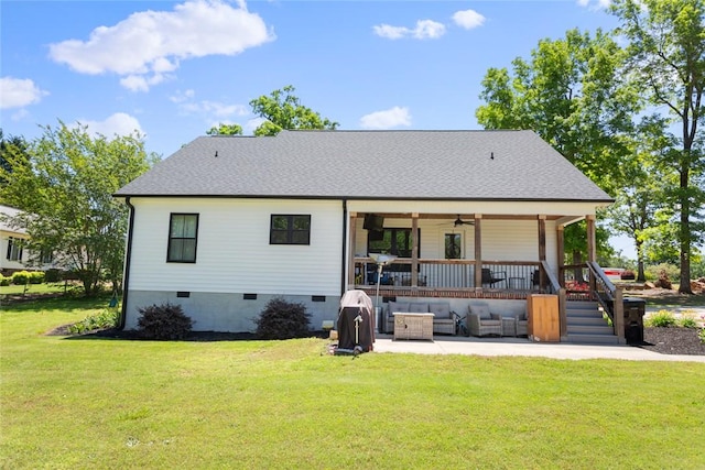 rear view of property featuring an outdoor living space, ceiling fan, a patio area, and a yard