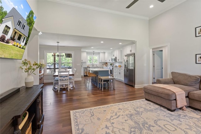 living room featuring a ceiling fan, crown molding, dark wood-style flooring, baseboards, and recessed lighting