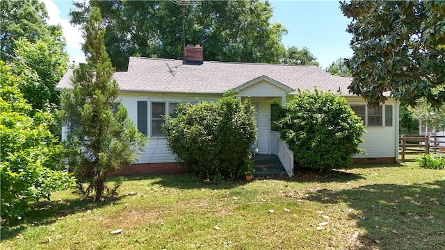 view of front of house with fence, crawl space, a chimney, and a front yard