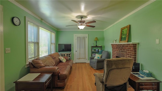 living area featuring ornamental molding, a fireplace, ceiling fan, and wood finished floors