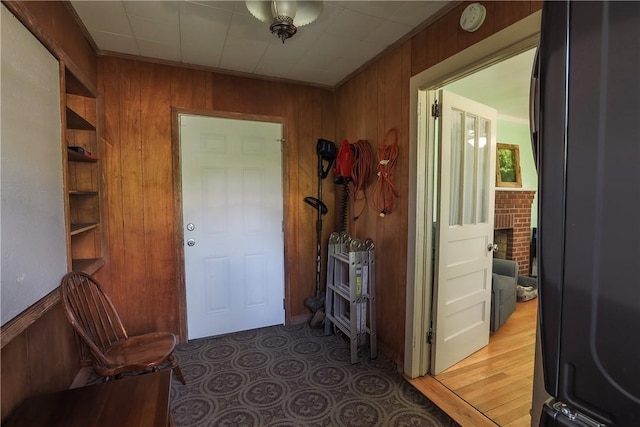 foyer featuring crown molding and wood walls