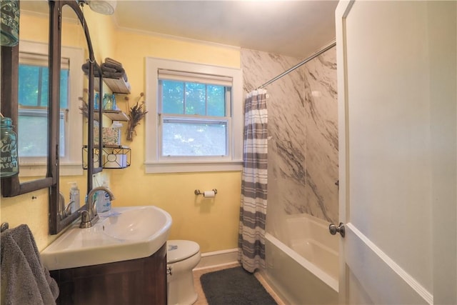 bathroom featuring shower / tub combo with curtain, vanity, toilet, and baseboards