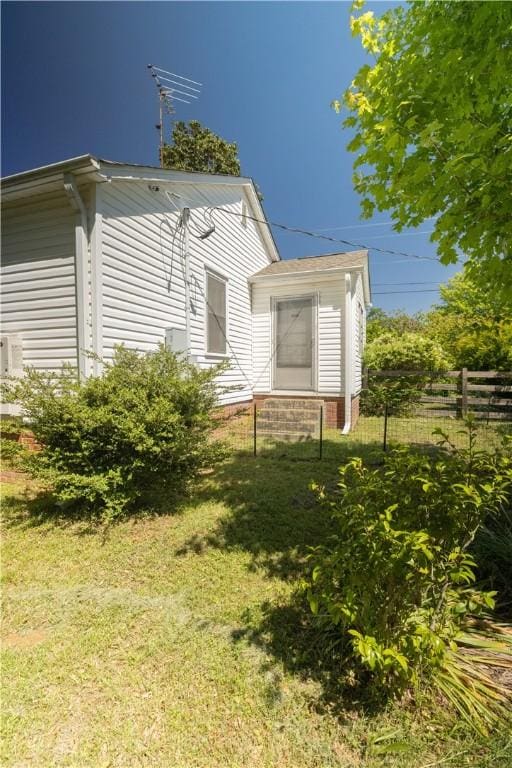 view of side of property featuring a yard and fence