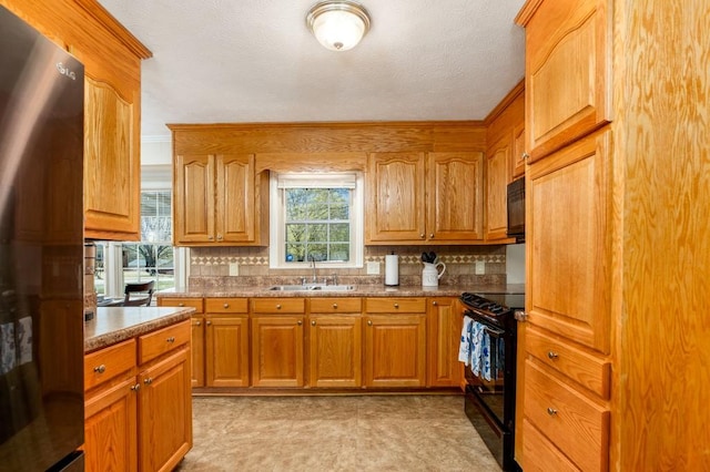 102 Norman St, Liberty, SC 29657 - kitchen featuring a sink, brown cabinetry, backsplash, and black appliances