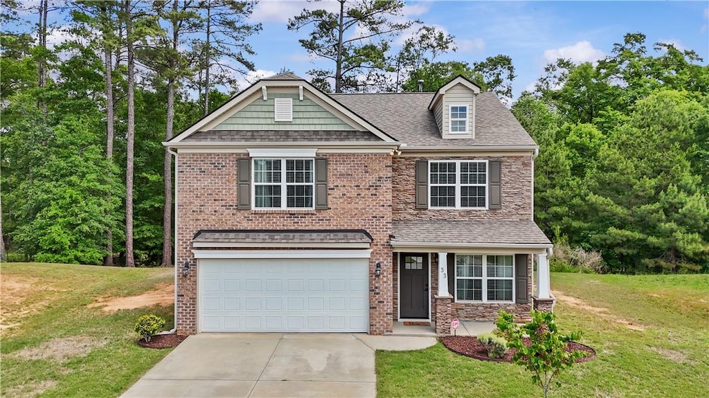 view of front of house featuring a garage, a front yard, a shingled roof, and driveway