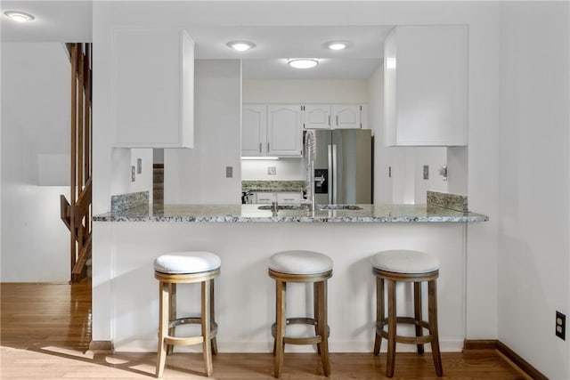 110 Safe Harbor Cir, Salem, SC 29676 - kitchen with stainless steel refrigerator with ice dispenser, white cabinets, light stone countertops, and a peninsula