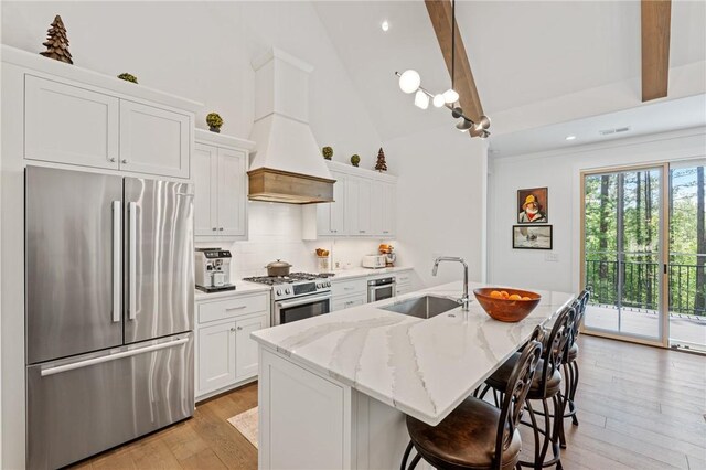 113 Settlement Village Dr, Sunset, SC 29685 - kitchen featuring appliances with stainless steel finishes, a sink, beamed ceiling, light wood finished floors, and an island with sink