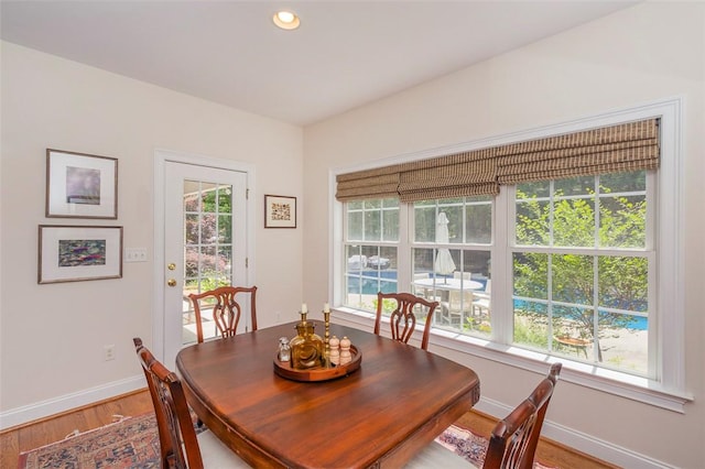 dining room featuring baseboards, wood finished floors, and recessed lighting