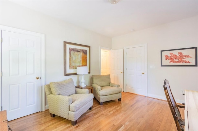 living area featuring light wood-style floors and baseboards