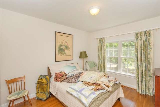 bedroom featuring wood finished floors and baseboards