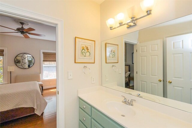 bathroom featuring connected bathroom, wood finished floors, a ceiling fan, and vanity