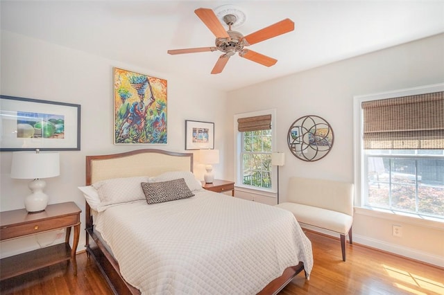 bedroom with baseboards, wood finished floors, and a ceiling fan