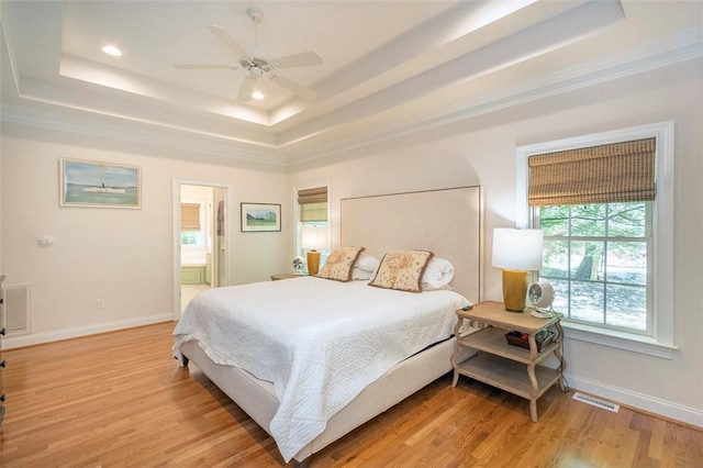 bedroom featuring a tray ceiling, baseboards, light wood-style flooring, recessed lighting, and a ceiling fan