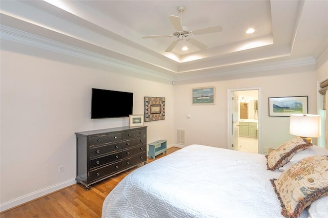 bedroom with a tray ceiling, wood finished floors, recessed lighting, baseboards, and ceiling fan