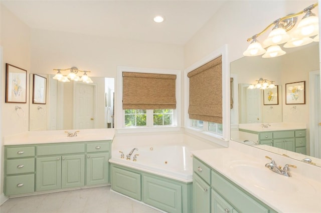 bathroom with a jetted tub, two vanities, a chandelier, and recessed lighting