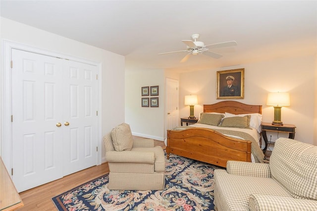 bedroom featuring wood finished floors, a closet, a ceiling fan, and baseboards