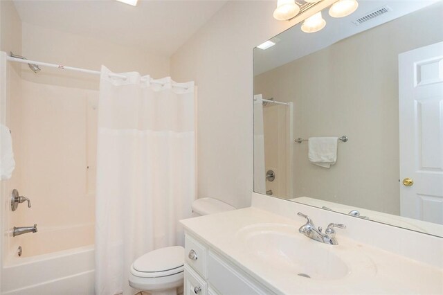 full bath with toilet, shower / bath combo with shower curtain, and vanity