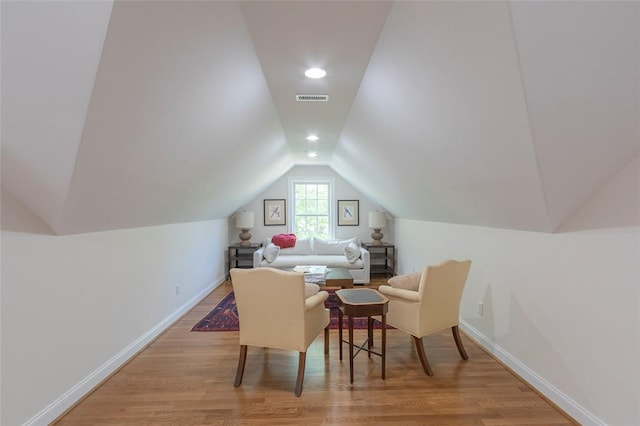 additional living space featuring vaulted ceiling, light wood-style flooring, and baseboards