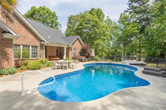 view of pool featuring a patio area, fence, outdoor dining space, and a hot tub