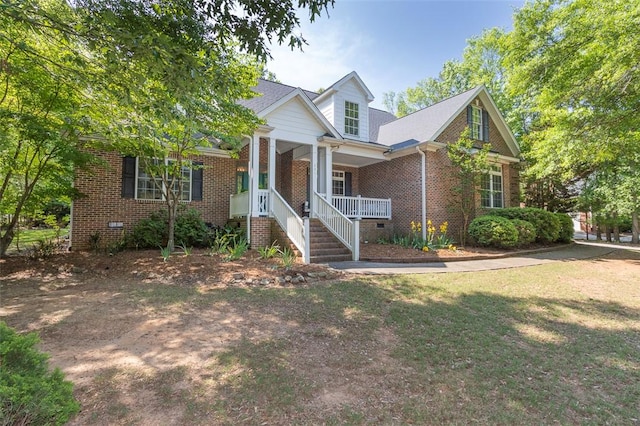 view of front facade featuring a porch, brick siding, a front yard, and crawl space