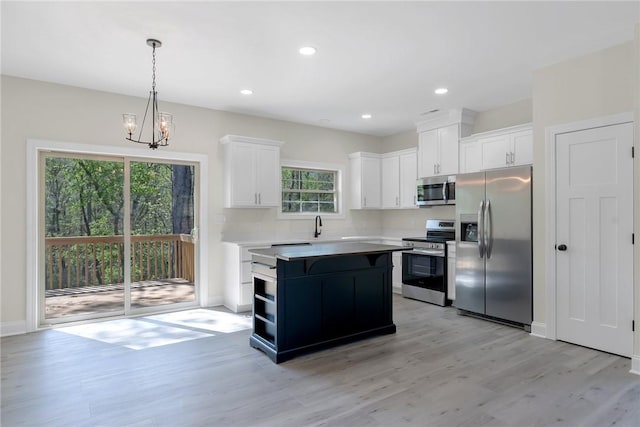 3062 Woodale Cir, Seneca, SC 29678 - kitchen featuring appliances with stainless steel finishes, light wood-style flooring, white cabinetry, a center island, and pendant lighting