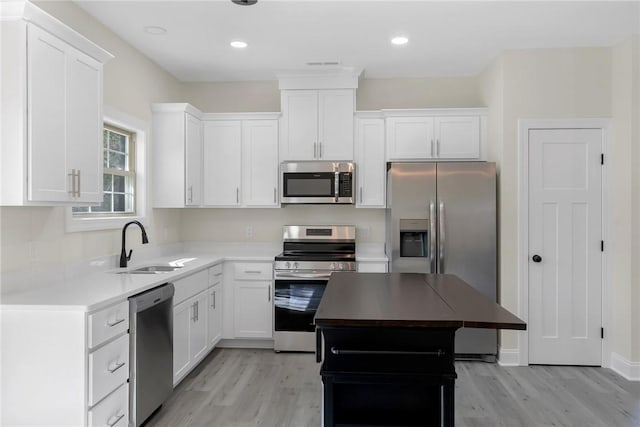 3062 Woodale Cir, Seneca, SC 29678 - kitchen with stainless steel appliances, a sink, light wood-type flooring, white cabinetry, and recessed lighting