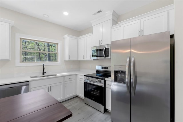 3062 Woodale Cir, Seneca, SC 29678 - kitchen with appliances with stainless steel finishes, a sink, light wood-style floors, white cabinetry, and light countertops