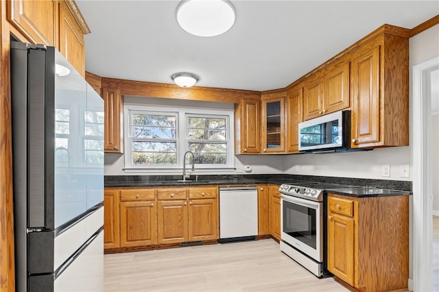 1102 Garrison Rd, Anderson, SC 29625 - kitchen featuring stainless steel appliances, brown cabinetry, light wood-style flooring, and a sink