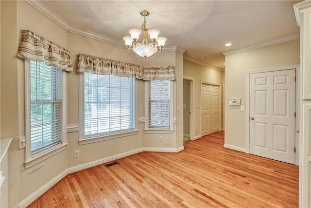 empty room featuring a chandelier, light wood-style floors, ornamental molding, baseboards, and recessed lighting