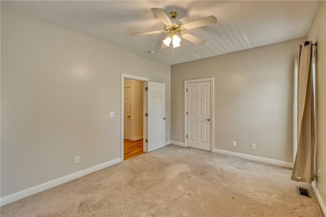 unfurnished bedroom with light carpet, baseboards, and ceiling fan