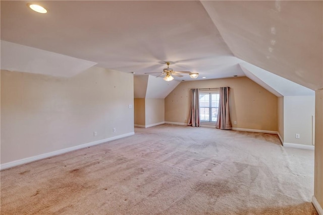 additional living space with vaulted ceiling, carpet flooring, baseboards, and a ceiling fan