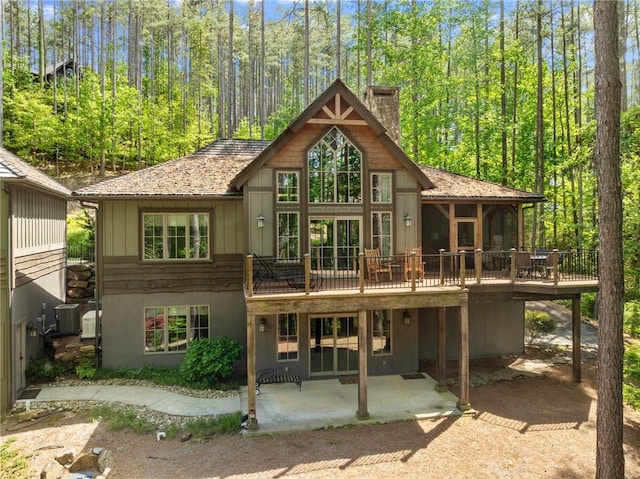 109 Laurel Pond Way, Sunset, SC 29685 - rear view of house featuring a patio, a chimney, a sunroom, a wooden deck, and board and batten siding