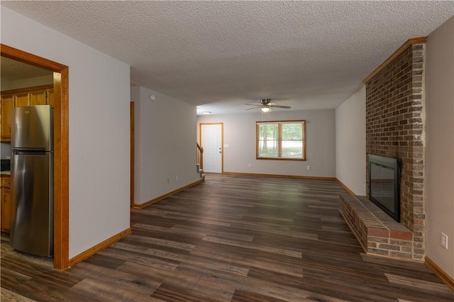 unfurnished living room featuring dark wood-style floors, a textured ceiling, a ceiling fan, a fireplace, and baseboards