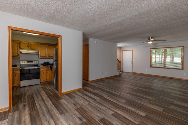 unfurnished living room featuring dark wood-type flooring, a textured ceiling, ceiling fan, baseboards, and stairway